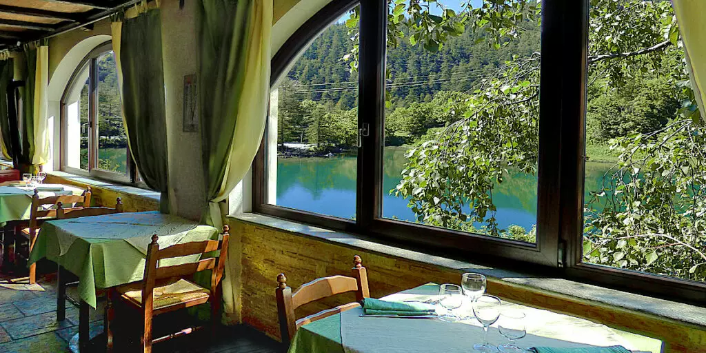 Salle à manger avec vue sur le lac. Hôtel dans les montagnes Piémont